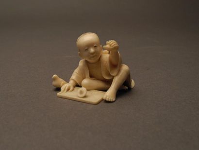 JAPON Netsuké en ivoire sculpté représentant un enfant jouant à la toupie