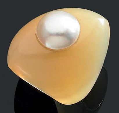 SUZANNE BELPERRON Bague "casque" en agate blonde rehaussée d'une demi perle. Fèle...