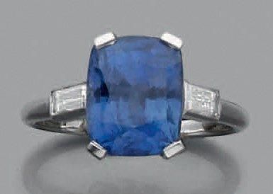 CARTIER Bague en platine ornée d'un saphir épaulé de deux diamants de taille baguette....