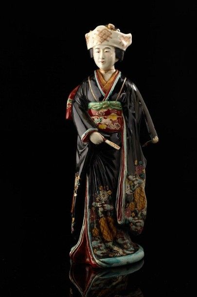 JAPON (ARITA) Grande figurine représentant un bijin en kimono noir cerné de fleurs...