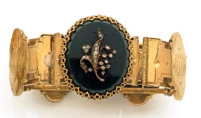 null Bracelet en or jaune 18 k articulé de quatre motifs ciselés et orné au centre...