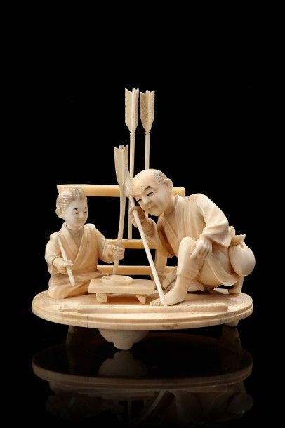 JAPON Okimono en ivoire sculpté représentant un père et son fils fabriquant des flèches....