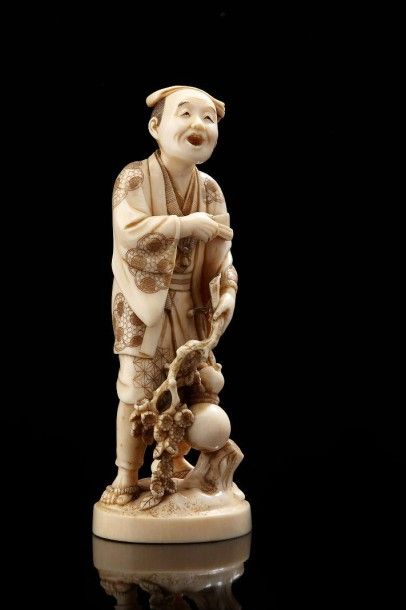 JAPON Okimono en ivoire sculpté représentant un personnage tenant un eventail d'une...