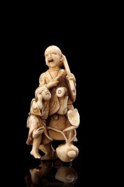 JAPON Okimono en ivoire représentant un homme, une pipe à la main, un enfant à ses...