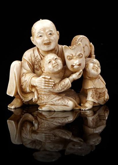 JAPON Petit okimono en ivoire représentant un homme avec deux enfants, l'un tenant...