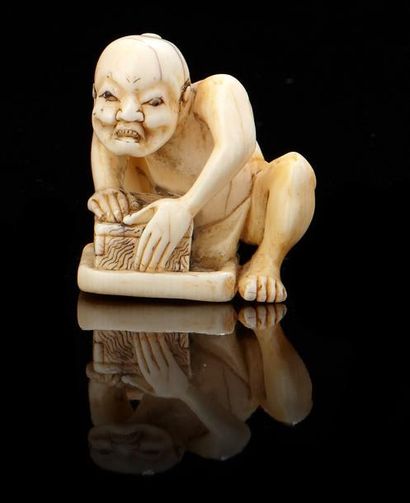 JAPON Netsuke en ivoire représentant un homme du peuple accroupi s'appuyant sur une...