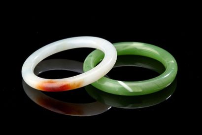CHINE deux bracelets en jade sculpté, l'un vert l'autre clair avec trace de rouille.-...