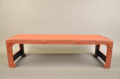 CHINE Table à thé en cuir laqué rouge à décor géométrique. Elle repose sur quatre...