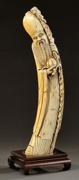 CHINE Sujet en ivoire sculpté représentant Hotei tenant la branche de longévité....