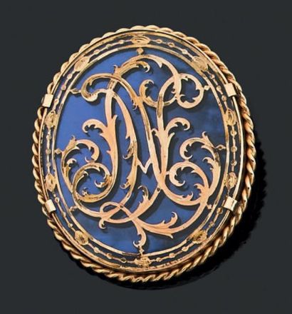 null Broche en or jaune 18k formant un médaillon sur fond bleu appliqué d'un monogramme...