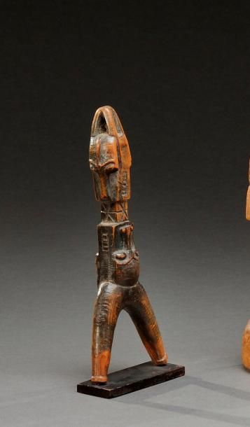 null Fronde Baoule de Côte d'Ivoire en bois dont le manche est sculpté de masques...