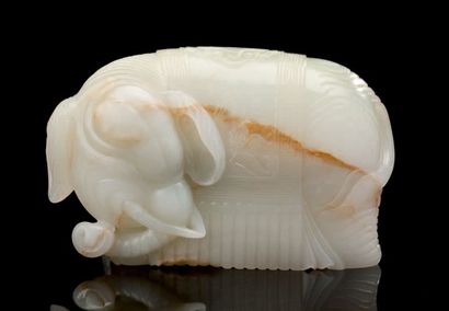 CHINE Figurine en jade clair avec traces de rouille représentant un éléphant harnaché...