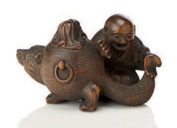 JAPON Netsuke en bois légende de la théière magique; un homme tient un Tanuki par...