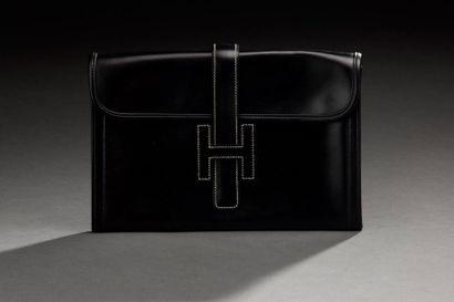 HERMES Pochette modèle "Jide" en cuir noir surpiqué noir, la languette et le monogramme...