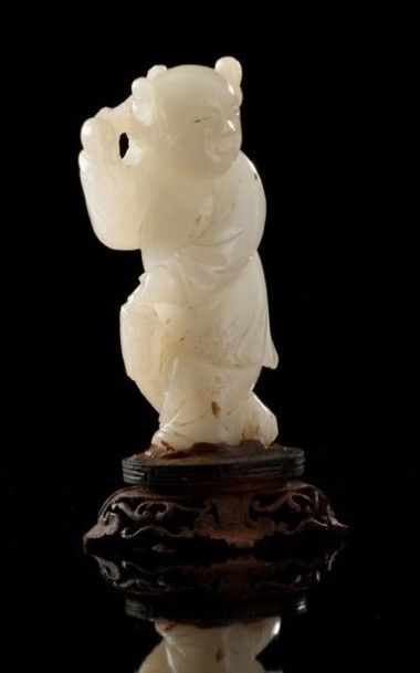 CHINE Figurine en jade clair représentant un enfant tenant un panier et une branche...