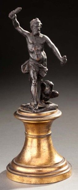 null Une statuette en bronze ciselé et patiné sur un socle en bronze doré représentant...