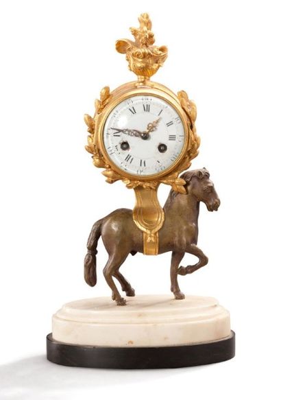 null Pendulette en bronze ciselé, doré ou patiné; le mouvement supporté par un cheval...