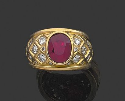 null Bague en or jaune 18K ornée d'un rubis ovale serti clos entre deux pavages à...