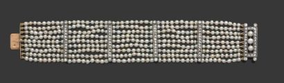 null Bracelet composé de 9 rangs de petites perles fines rythmés de barettes en or...