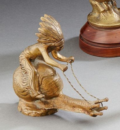 null Mascotte en bronze patiné figurant un indien chevauchant un escargot. Haut.:...