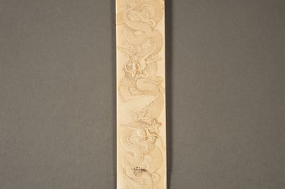 JAPON Grand coupe-papier en ivoire sculpté en léger relief de deux dragons à trois...