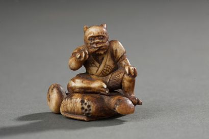 JAPON Netsuke ou petit okimono en os; Oni assis sur un sac; constitué de 2 pièces.
H:...