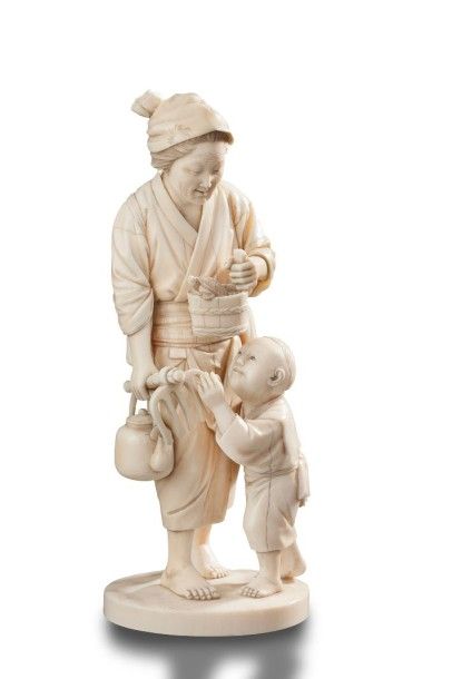 JAPON Okimono en ivoire sculpté représentant une paysanne et son enfant; elle tient...