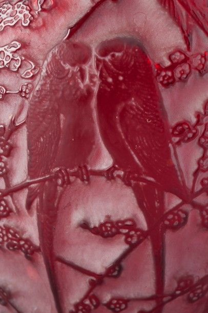 RENE LALIQUE (1860-1945) Vase "Perruches" en verre moulé-pressé teinté rouge patiné.
Signé.
Modèle...
