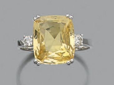 null Bague en or gris 18K sertie d'un saphir jaune épaulé de deux diamants de taille...