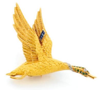 HERMES BROCHE "CANARD" en or jaune gravé, la tête sertie d'émeraudes et de brillants,...