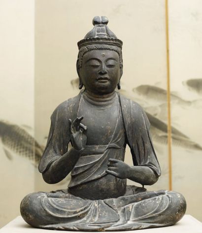  Belle et rare représentation en bois d'un bodhisattva assis. Il a la main droite...