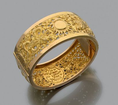 null Bracelet rigide en or jaune 18k (750) ajouré à décor de dragons entourant la...