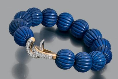 CARTIER Bracelet semi rigide composé de perles de lapis lazuli gravées de godrons.
Le...