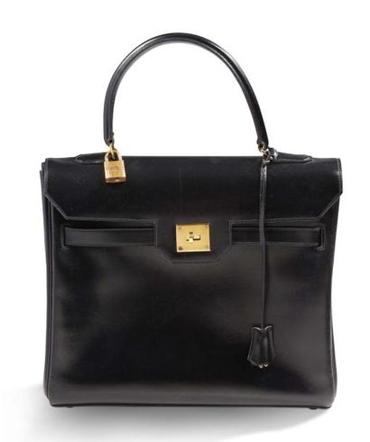 HERMES Sac Kelly en cuir noir. Garniture en métal doré. Poignée simple en cuir permettant...