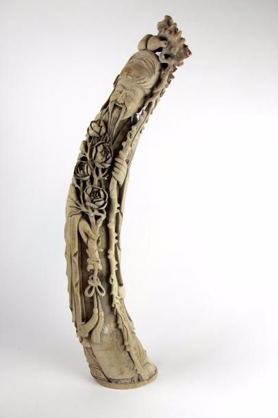null Statuette en ivoire représentant un sage tenant une branche de pivoinie en fleurs...