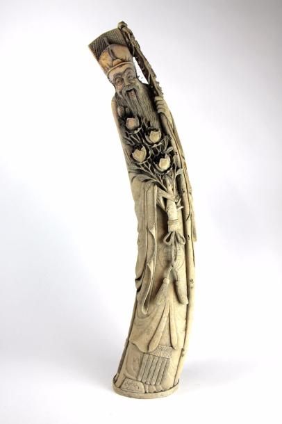 null Statuette en ivoire représentant un sage tenant une branche de pivoinie en fleurs...