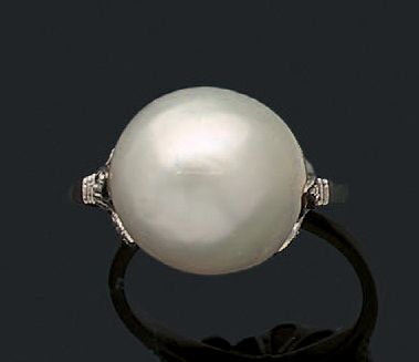 null Bague en platine (950) sertie d'un perle fine bouton épaulée de diamants taille...