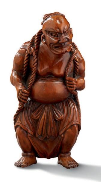 JAPON Grand netsuke en bois clair représentant un Nyô debout, portant dans son dos...