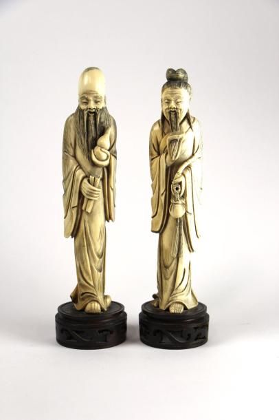 null Deux statuettes en ivoire représentant un dignitaire tenant la pipe et la blague...