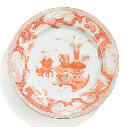 CHINE Deux assiettes rondes, l'une décorée en rouge de fer et or de «mobilier» chinois...