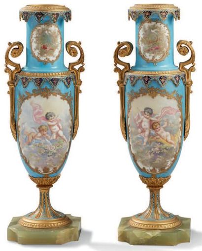 null PAIRE DE VASES en porcelaine à fonds turquoise et réhauts dorés à décors d'angelots...