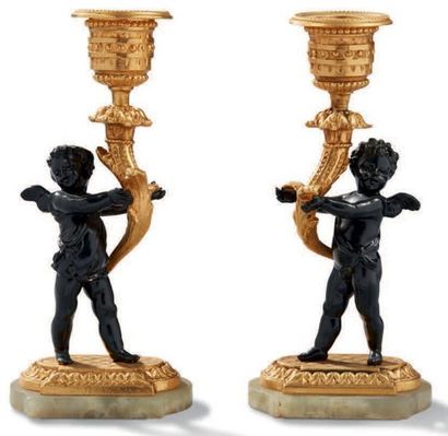 null PAIRE DE PETITS BOUGEOIRS en bronze doré et métal patiné soutenus par deux angelots
XXème...