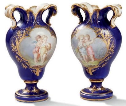 SÈVRES (GENRE DE) Paire de vases à anses en porcelaine à fonds gros bleu et rehauts...