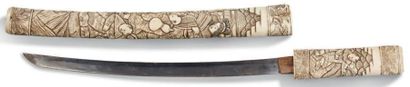 JAPON VERS 1940 Petit sabre en os avec fourreau et poignée sculptée de personnages...