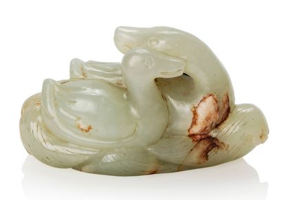 CHINE 
Pendentif en jade céladon légèrement veiné de rouille, représentant un couple...