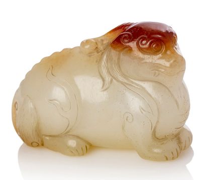 CHINE 
Pendentif en jade blanc veiné de rouille, représentant un Qilin allongé.
L....
