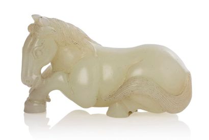 CHINE VERS 1900 Sujet en jade blanc représentant un cheval allongé, la tête reposant...