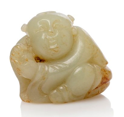 CHINE 
Petit sujet en jade, céladon veiné de rouille représentant un enfant assis.
H....