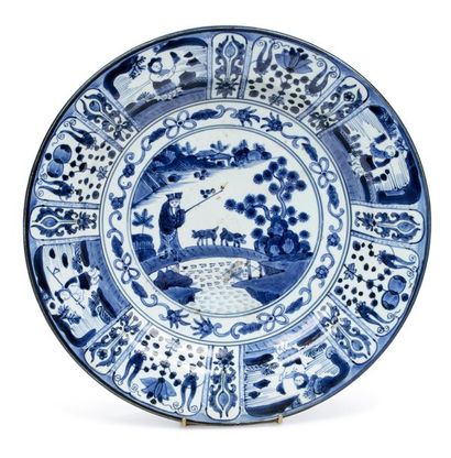 JAPON 
Grand plat en porcelaine d'Arita, à décor en bleu sous couverte d'un berger...
