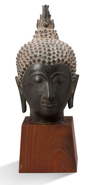 THAILANDE 
Tête de bouddha en bronze, les yeux mi-clos et esquissant un léger sourire,...